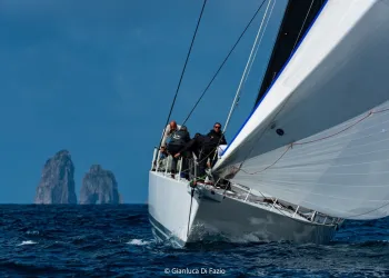 Barca da regata d'altura con equipaggio che naviga a vela su mare aperto