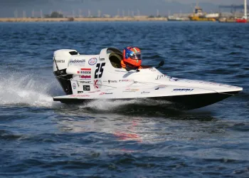 Monoscafo da gara GT30 bianco con pilota dal casco arancione che sfreccia sull'acqua