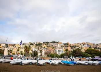 Derive coperte sui carrelli sulla spiaggia, con cielo nuvoloso e case colorate sulla collina sullo sfondo
