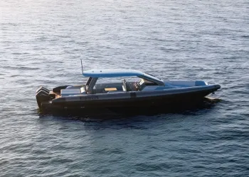 Gommone scuro con hard top azzurro e due motori fuoribordo in navigazione su mare calmo, visto dall'alto