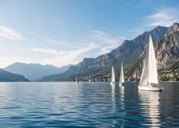 Vele in navigazione sul ramo lecchese del Lario con montagne sullo sfondo